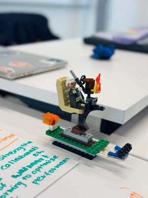  During an in-class activity, we built with Lego a knight figure holding a torch, placed on a small platform beside a sheet of paper and laptop on the table.