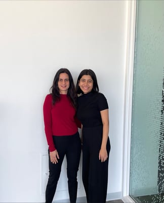 Professor Rovena Aga and Anam Shaikh standing next to each other infront of a white wall.