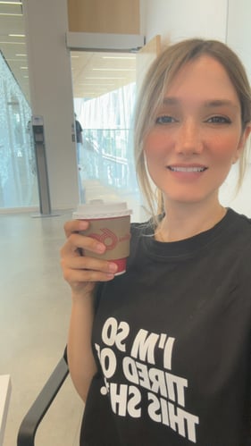 A selfie of a young girl smiling at the camera In the class and holding a cup of Tim Horton’s coffee.
