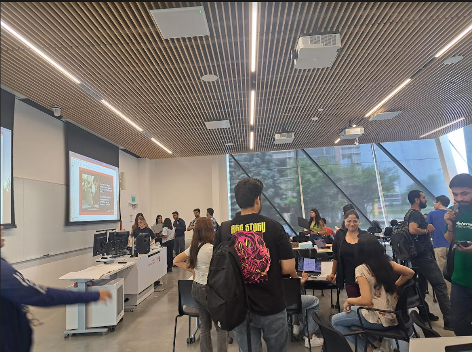 Students at York University School of Continuing Studies standing and smiling in a classroom at the end of class, showing a positive and engaged learning environment