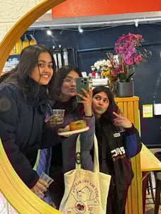 Three friends taking a mirror photo, all smiling and posing together