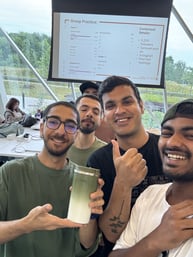 A group of four boys smiling and clicking a selfie in a classroom at YSCS with one of the boy showing thumbs up and student sitting in the background