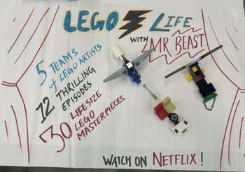 Three lego artworks on a sheet of paper with curtains drawn on the left and right hand side, text saying lego life with Mr. Beast and details of the event