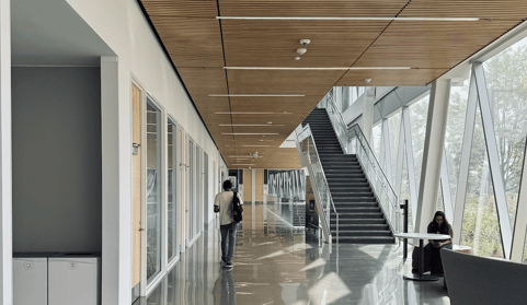 Photo of the interior of the SCS building at York University. Two international students are present, with stairs and numerous classrooms on the right.