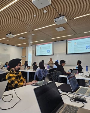 A professor teaching and providing valuable insights in class while students listen attentively and take notes on their laptops.