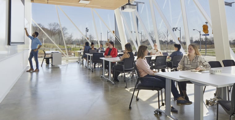 A diverse group of students sitting at tables in a classroom for studying at York University School of Continuing Studies.