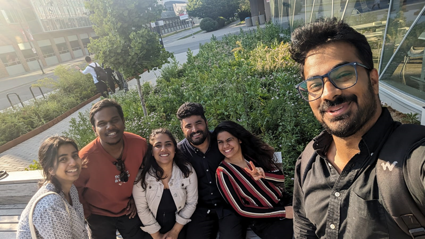 Group picture of six students posing outside of the York U SCS campus.