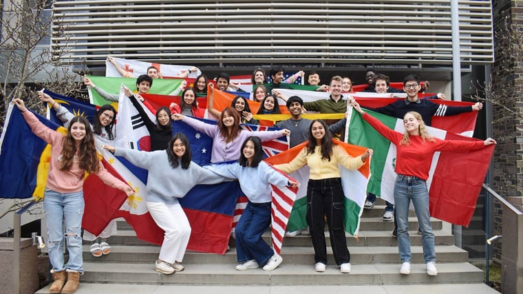 A vibrant gathering of international students displaying flags, representing their countries, and encouraging cultural interchange and unity.