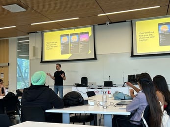Man presenting to people in a York SCS room with two discplay screens in the background