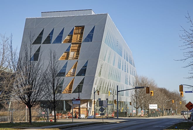 The York School of Continuing Studies building where classes take place. There are bare trees and a road with traffic signals in the foreground.