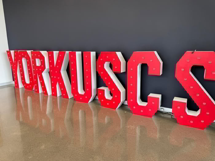 Big red and white "YORKUSCS" lettering was displayed against a black background, reflecting off a polished floor.