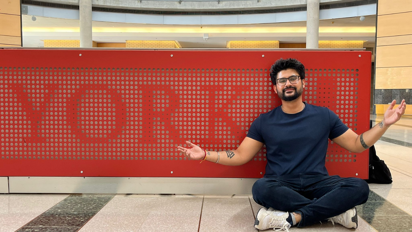 Harshit Student at york university sitting in front of the board with york University logo in the centre of college building