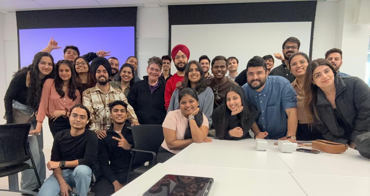 A large group of smiling students, representing diverse backgrounds, gathered closely together in a classroom setting. They are celebrating their last day at York, with everyone looking cheerful and engaged.