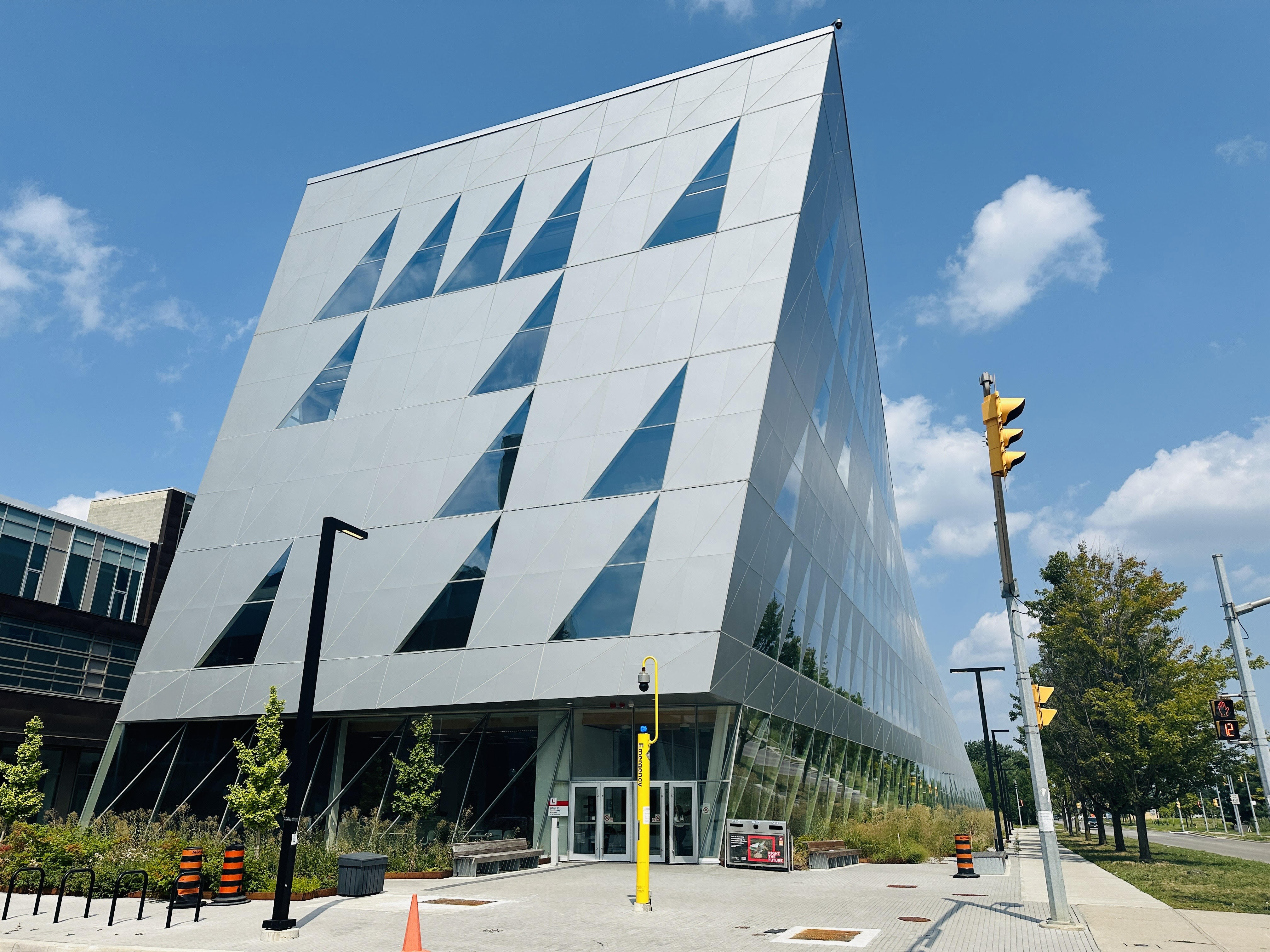 Modern angular building with geometric facade under blue sky.