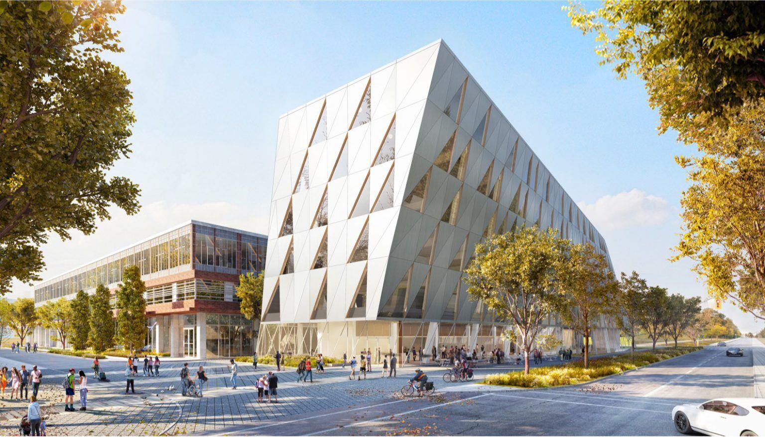 A modern, geometric building on York University's campus with a triangular pattern on its façade along with large glass windows. The structure stands along a tree-lined street, with people walking and biking nearby.